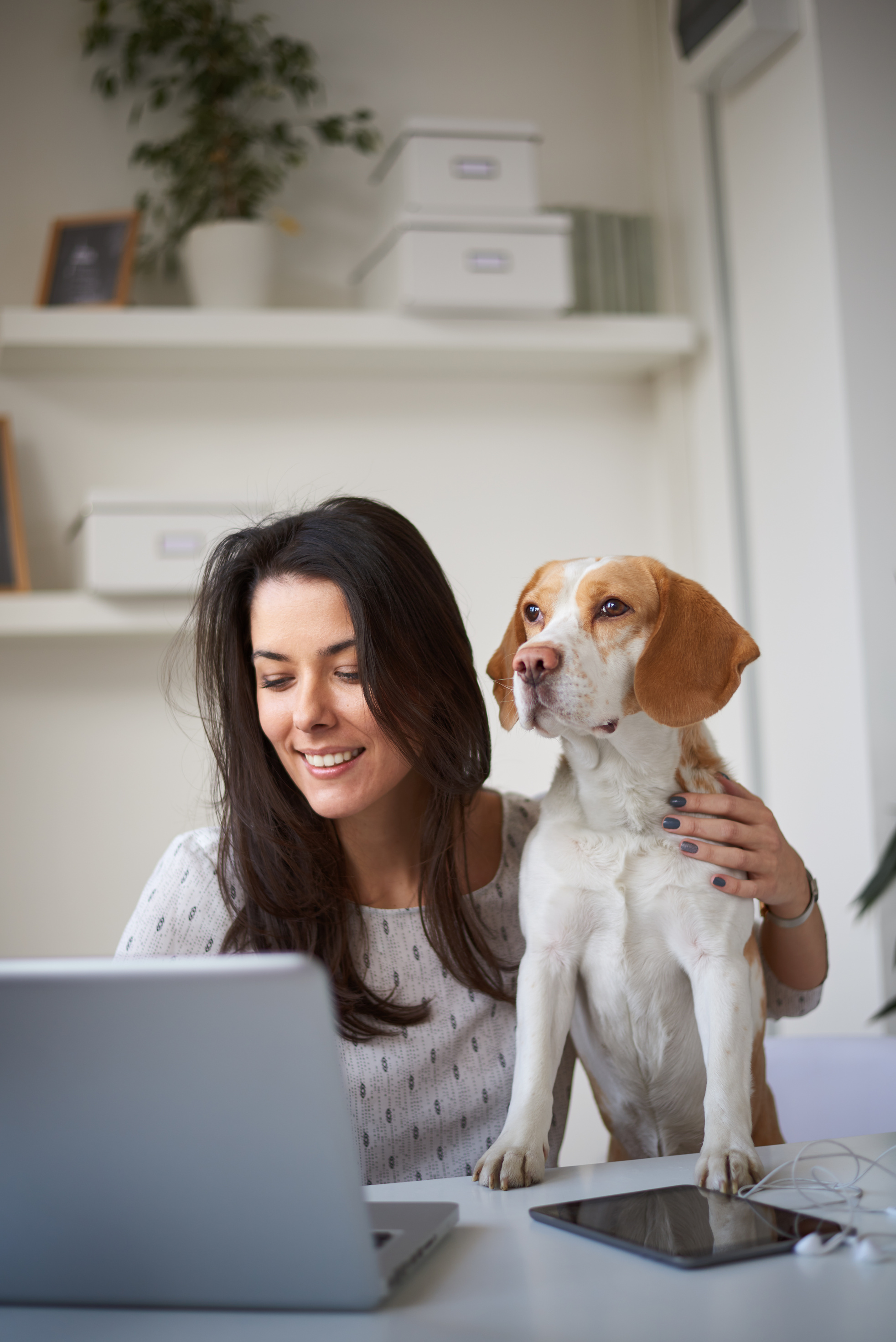 Woman sitting in home office with her dog.